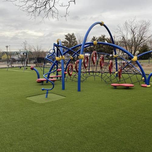 playground with blue jungle gym and artificial grass
